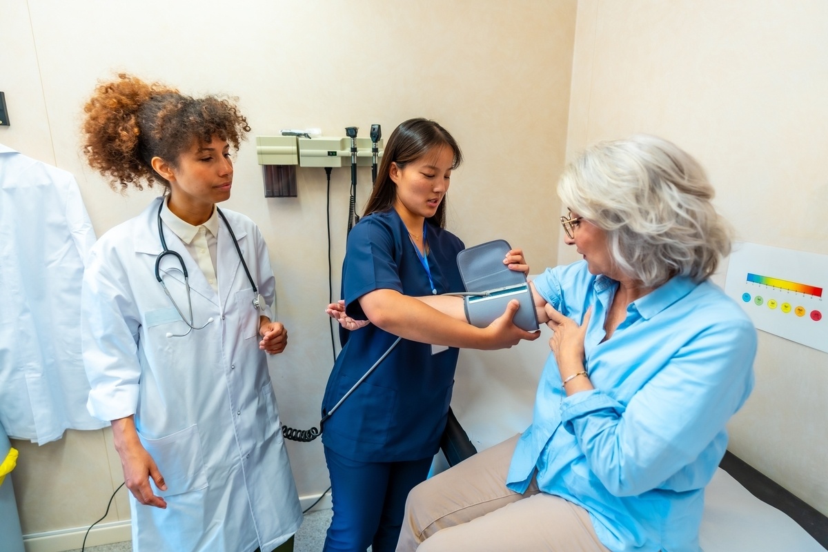 Medical assistant in scrubs taking patient blood pressure during medical assistant classes in Queens NY at IP Training School